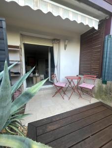 a patio with two pink chairs and a table at Studio pratique - Jardin privé in Grabels