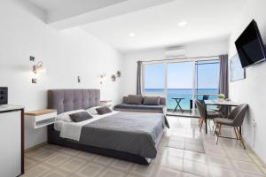 a bedroom with a bed and a view of the ocean at Julies Studios in Chania