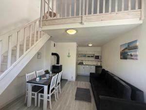 a living room with a black couch and a table at Apartamenty Łuska Rowy in Rowy
