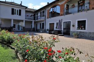 a house with red flowers in front of it at Casale del Miglio in Casorzo