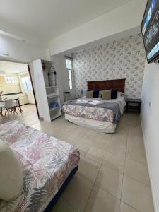 a bedroom with two beds and a dining room at San Francisco in Comodoro Rivadavia