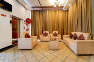 a living room with couches and chairs and curtains at Hotel O by OYO REFRESH INN & SUITES in Kozhikode