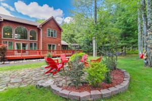a yard with red chairs and a house at Split Rock Resort: Family Getaway w/ Fire Pit! in Lake Harmony