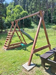 a playground with a slide and a swing at Chata pod vŕškami Važca in Važec