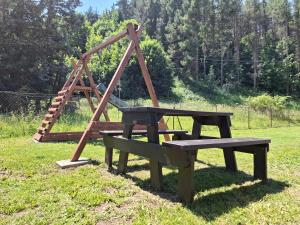 a wooden playground with a bench and a swing at Chata pod vŕškami Važca in Važec