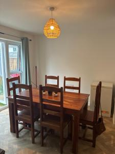 a dining room table with four chairs and a light fixture at StaywithusHighbridge in Highbridge