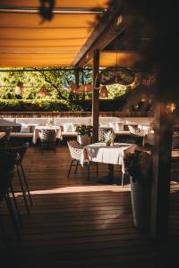 a restaurant with tables and chairs on a wooden deck at ROHO MURAU Hotel Rosenhof Murau in Murau