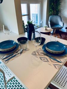 a table with blue plates and wine glasses on it at Station -Mansarda in posizione strategica, vista panoramica, letto king size e clima in Ivrea