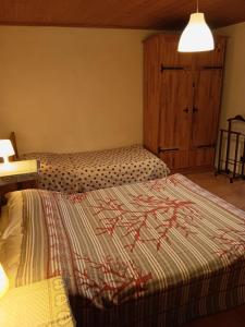 a bedroom with a bed and a cabinet and a lamp at La Casa Antica in Pont-Saint-Martin +10 photos