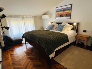 a bedroom with a bed and a chair in it at Station -Mansarda in posizione strategica, vista panoramica, letto king size e clima in Ivrea