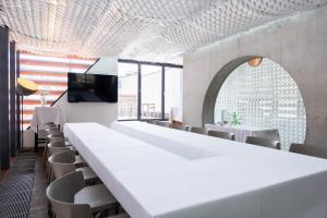a large dining room with white tables and chairs at Vander Urbani Resort - a Member of Design Hotels in Ljubljana