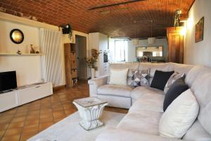 a living room with a white couch and a television at Casale del Miglio in Casorzo