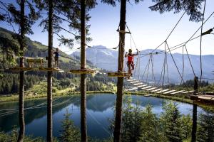 a group of people on a suspension bridge over a lake at Alpinchalet Eisenerz in Eisenerz