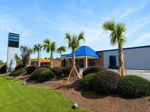 a building with palm trees in front of it at Clarion Inn in Greenville