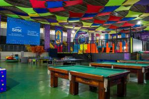 a room with ping pong tables and a colorful ceiling at Sesc Venda Nova in Belo Horizonte