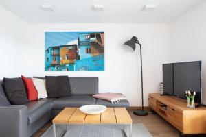 a living room with a couch and a tv at Ferienwohnung Süßenmühle Naturstrand in Sipplingen