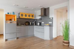 a kitchen with white cabinets and yellow accents at Ferienwohnung Süßenmühle Naturstrand in Sipplingen +8 photos