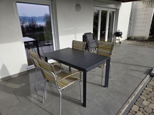 a black table with two chairs and a bag on it at Ferienwohnung Süßenmühle Naturstrand in Sipplingen