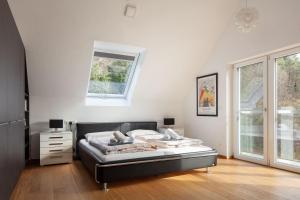a bedroom with a bed in a room with a window at Studio Süßenmühle mit viel Privatsphäre, direkt am Naturbadestrand in Sipplingen