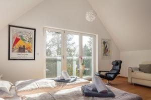 a room with two beds and a chair and a window at Studio Süßenmühle mit viel Privatsphäre, direkt am Naturbadestrand in Sipplingen +4 photos
