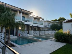 a house with a swimming pool in front of it at Anemone Premium Suites Faliraki in Faliraki