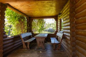 a porch with two benches and a table in a cabin at Green park residence in Tīnūži