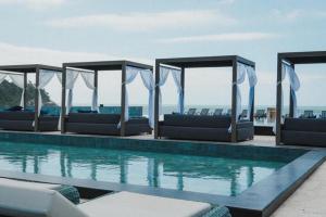 a swimming pool with lounge chairs and the ocean at Hotel Blue Sea in Itapema