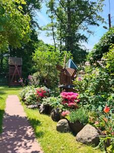 a garden with flowers and a path at Dom Gościnny Sówka in Pobierowo