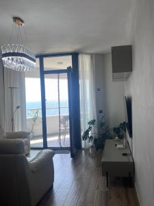 a living room with a couch and a large window at The Touch of the Sea in Durrës