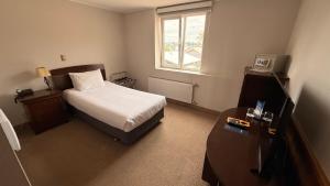 a small bedroom with a bed and a window at Park Inn by Radisson Puerto Varas in Puerto Varas