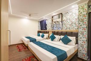 two beds in a hotel room with blue pillows at Family Group with Provide By PG Hotel Near New Delhi Railway station & Karol-Bagh in New Delhi