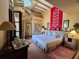 a bedroom with a bed and a red wall at Hacienda de Orán in Utrera +62 photos