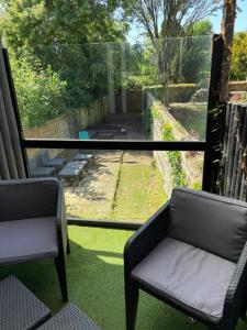 a balcony with two chairs and a view of a yard at Le Beverl'inn in Flers