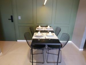 a dining room table with chairs and a table with dishes on it at LK Funcionários 6 in Belo Horizonte