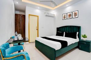 a bedroom with a bed and a blue chair at Hotel O Jaimantri Palace in Bihār Sharīf