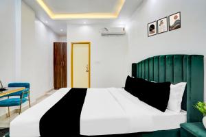 a bedroom with a bed and a blue chair and a desk at Hotel O Jaimantri Palace in Bihār Sharīf
