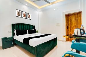 a bedroom with a green bed and a blue chair at Hotel O Jaimantri Palace in Bihār Sharīf