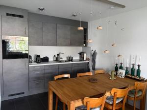 a kitchen with a wooden table with chairs and a kitchen with a tableablish at Apartmenthaus Gauenpark - CharmingStay in Flumserberg
