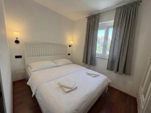 a bedroom with a white bed with two towels on it at Moro Crikva in Crikvenica
