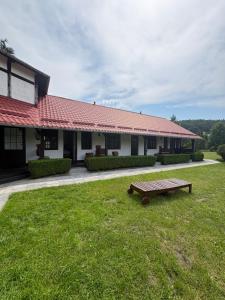 a building with a bench in the grass in front of it at Gościniec u Bernackich in Smołdzino +12 photos