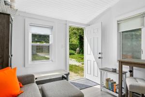 a living room with a couch and a window at Bed, Splash Beyond – Coastal Comfort Awaits in Orleans