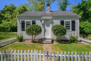 a white house with a white picket fence at Bed, Splash Beyond – Coastal Comfort Awaits in Orleans