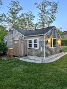a small building with a yard with a house at Bed, Splash Beyond – Coastal Comfort Awaits in Orleans