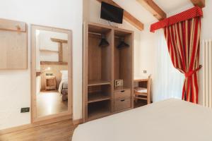 a bedroom with a bed and a large mirror at Hotel Selva in Folgarida +38 photos