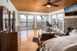 a bedroom with a bed and a living room with a fireplace at Misty Ridge Retreat in Blowing Rock