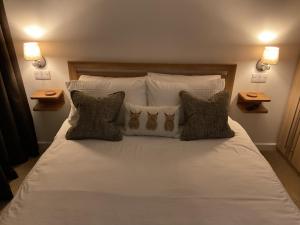 a bedroom with a large bed with white sheets and pillows at Gara-Ni Bed & Breakfast in Fort William