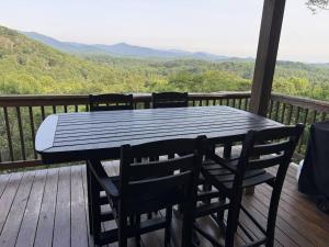 a black table and chairs on a deck with a view at Misty Ridge Retreat in Blowing Rock