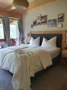 a bedroom with a large bed with white sheets and pillows at Bichlhof in Kaisers