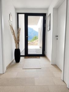 a hallway with a door and a vase with a plant at Das Mondsee-Retreat in Innerschwand