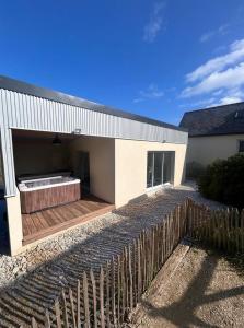 a white house with a fence in front of it at Le cocon de Jules et Chloé in Cléder